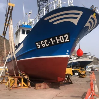 Fotografia de barco color azul y rojo pintado con pinturas náuticas Jotun
