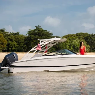 Bote de color blanco y modelo con traje de baño rojo en el bote