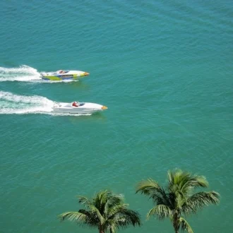 Fotografia de dos botes de carrera compientdo en el mar